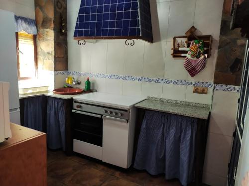 a kitchen with a sink and a stove top oven at Alojamiento Rural Mendoza in Martos