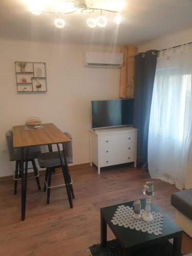 uma sala de estar com uma mesa e uma televisão em MINT APARTMENTS em Zadar