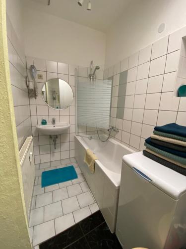 a bathroom with a tub and a sink and a mirror at Apartment Pension Sternchen in Erfurt