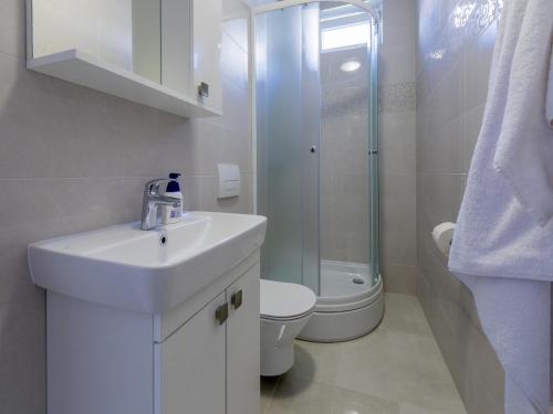 uma casa de banho branca com um lavatório e um WC em Apartments Elizabeta em Dramalj