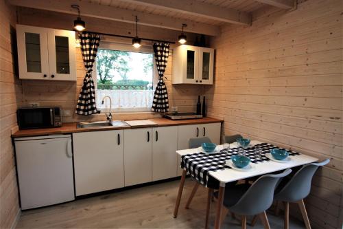 a kitchen with white cabinets and a table with chairs at Domek pod Ślężą in Marcinowice