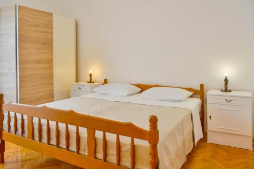 a bedroom with a wooden bed with two night stands at Apartman Gabrijela in Senj