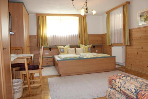 1 dormitorio con cama, escritorio y ventana en Ferienwohnung Irene, en Tux
