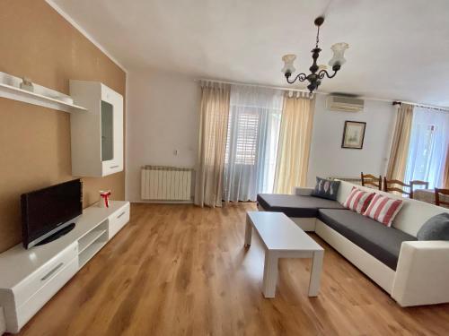 a living room with a couch and a tv at Apartman Mira in Opatija