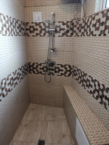 a bathroom with a shower with a bench and a tub at Hotel My House in Kŭrdzhali
