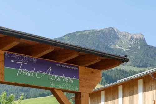 a sign on a building with a mountain in the background at Trendapartment in Russbach am Pass Gschütt