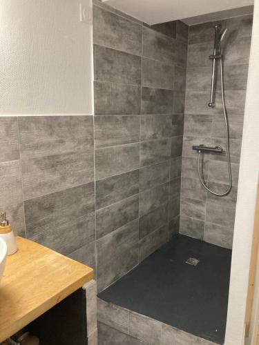 a bathroom with a shower with gray tiles at A la croisée des chemins in Saint-Nicolas-des-Biefs