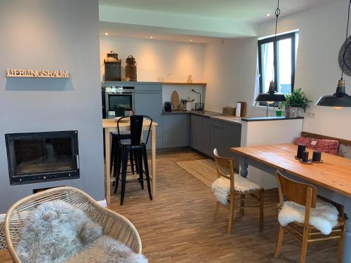 a kitchen and living room with a table and chairs at Haus & Hof Guest House in Perl