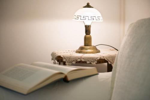a lamp sitting on a table next to an open book at Antico Borgo Teresiano in Trieste