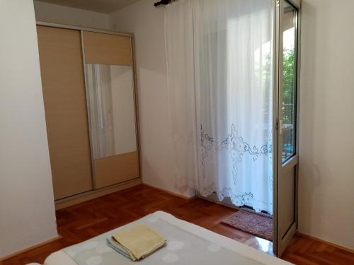 a room with a bed and a window and a mirror at Apartments Anita Hure in Hvar