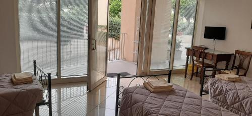 a bedroom with two beds and a desk with a television at Casa per ferie religiosa Figlie di Nazareth in Pisa
