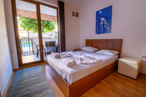 een slaapkamer met een bed en een groot raam bij Apollon Apartments in Nesebar