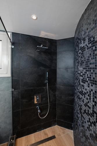 a bathroom with a shower with a black wall at Maran Residence in Cairo