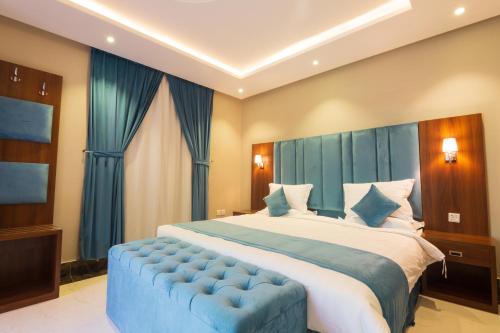 ein Schlafzimmer mit einem großen Bett und einer blauen Couch in der Unterkunft بالم تري للشقق المخدومه in Riad