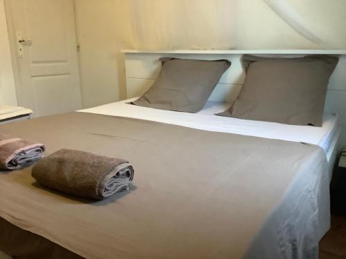 a large white bed with two towels on it at VILLA ALIZÉE Logement 3 in Sainte-Rose