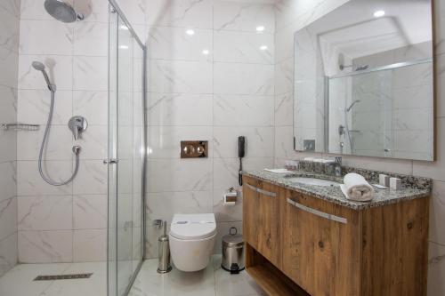 a bathroom with a shower and a toilet and a sink at Dalya Resort Aqua & Spa Hotel Datça in Datca