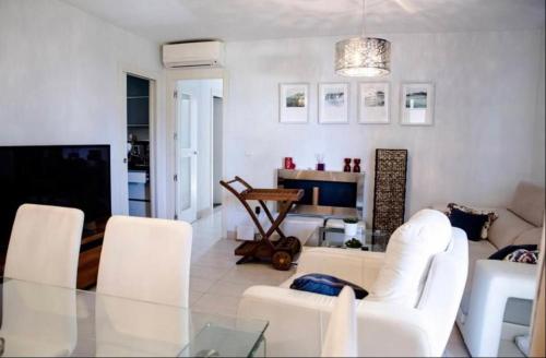 a living room with white furniture and a television at Pez Espada 1ª Línea Playa y Parking Incluido in Torremolinos
