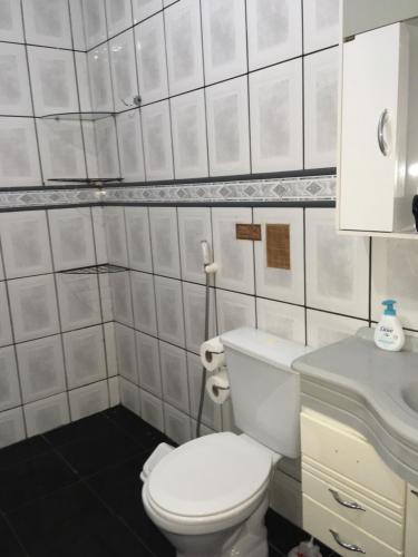 uma casa de banho com um WC branco e um lavatório. em Quarto INDIVIDUAL Casa Super Aconchegante WIFI 350 MEGA em Osasco