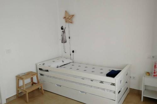 a white bed in a room with a wooden table at Ses Venes 1 in Maria de la Salut