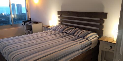 a bedroom with a bed with a wooden headboard and a window at Vista Privilegiada in Punta del Este