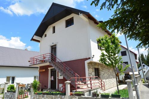 a house with a red staircase in front of it at MM Apartments in Žabljak