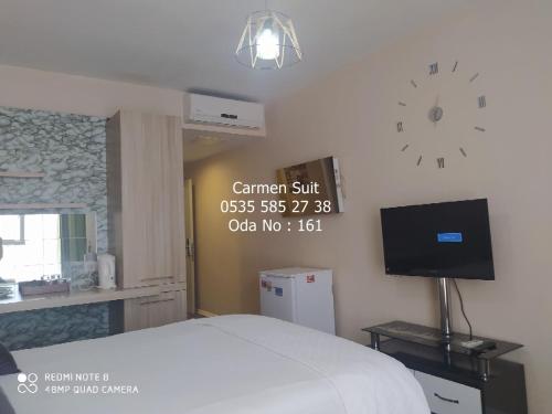 1 dormitorio con 1 cama y reloj en la pared en Carmen Suite Tuyap, en Beylikduzu