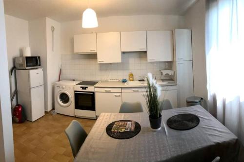 une cuisine avec une table avec des chaises et un micro-ondes dans l'établissement Appart T2 spacieux proche Gare TGV, au Mans