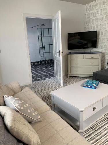 a living room with a couch and a coffee table at Portaferry Waterfront Townhouse with Hot Tub in Portaferry