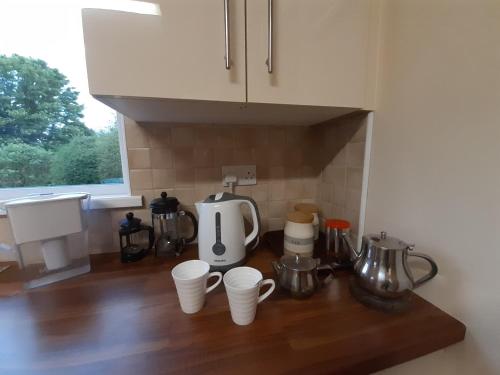 a kitchen counter with cups and appliances on it at Home from home in East Galway in Ballycrossaun