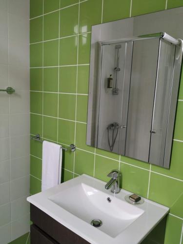 La salle de bains est pourvue d'un lavabo et d'un miroir. dans l'établissement Casa Archie, à São Pedro do Sul