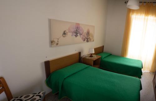 um quarto com 2 camas verdes e uma janela em Casa Vacanza da Tonino em Ischia