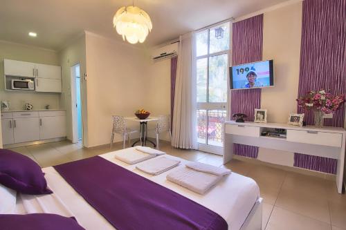 a large bedroom with a large bed and a kitchen at 1926 Designed ApartHotel in Haifa