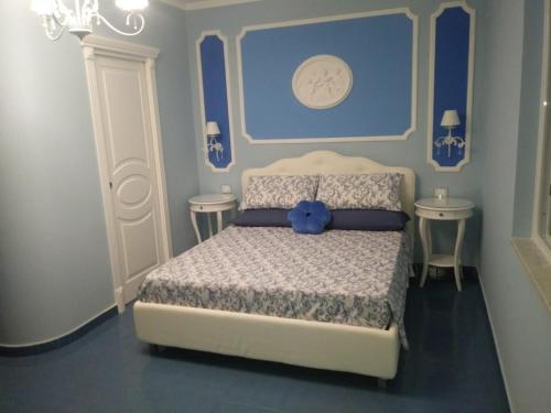 a bedroom with a bed with a blue head board at B&B Domus Anfra in Agropoli