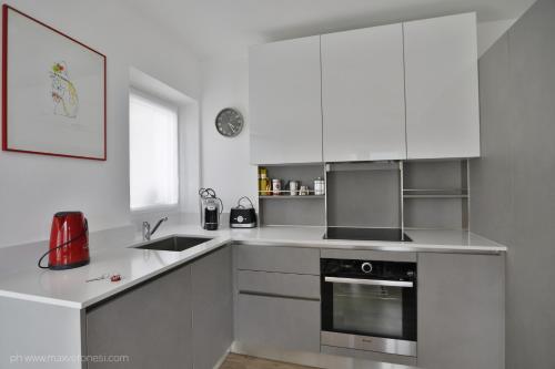 a white kitchen with a sink and a stove at Appartamenti Ramarro in Ronco s/Ascona - Porto Ronco