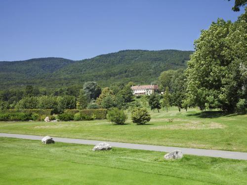 a road in a field with a house in the background at Château de Bonmont in Cheserex