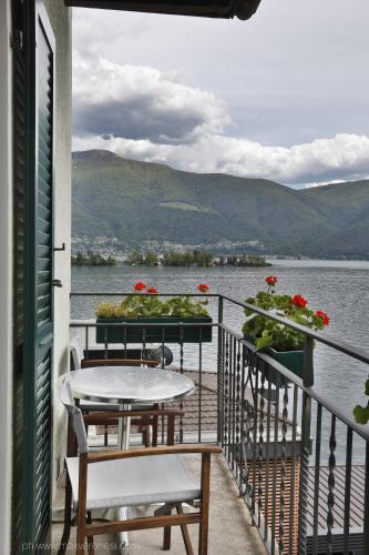 a balcony with a table and chairs and a view of the water at Appartamenti Ramarro in Ronco s/Ascona - Porto Ronco