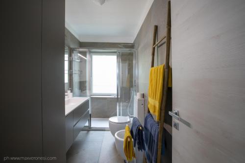 a bathroom with a toilet and a sink and a window at Appartamenti Ramarro in Ronco s/Ascona - Porto Ronco