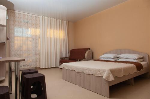 エイスクにあるМой Дом в Ейске на Краснодарской 119のベッドルーム1室(ベッド1台、椅子付)