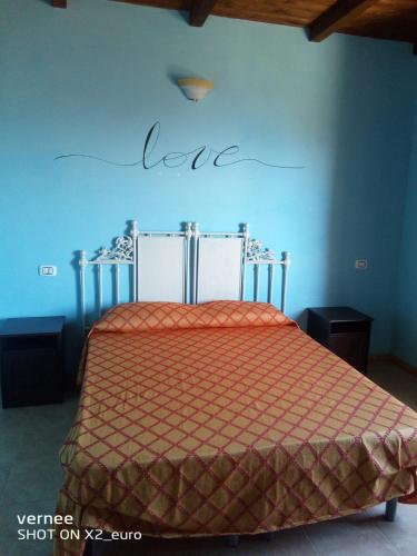 a bedroom with a bed with the word love on the wall at Le Terrazze di Martina in Nicotera