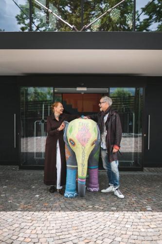 a man and a woman standing next to an elephant at Hotel Gartner in Tirolo