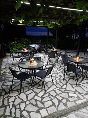 a group of tables and chairs on a patio at BATO Rooms in Peštani