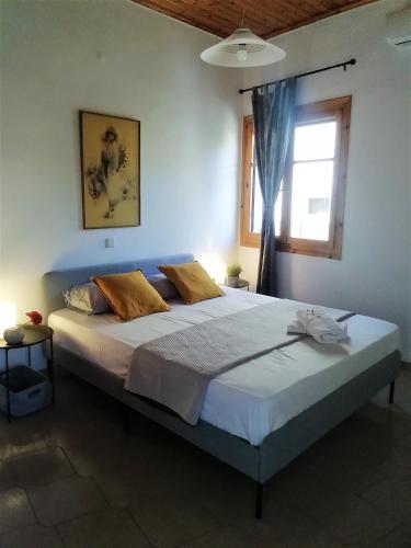 a large bed in a bedroom with a window at Petrochori Memories House- Floor 1 in Petrochori