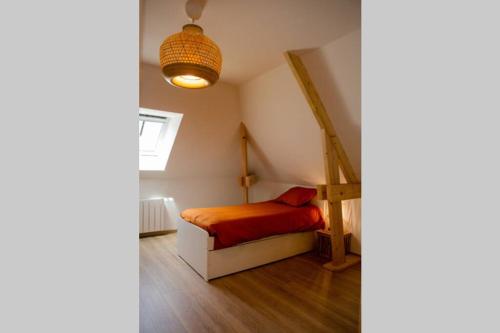 a small bedroom with a bed and a staircase at l'Atelier du menuisier in Amboise