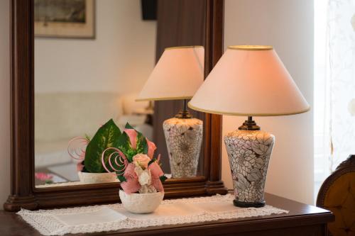 two vases sitting on a table in front of a mirror at Antico Borgo Teresiano in Trieste