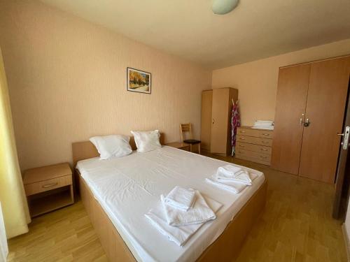 a bedroom with a white bed with two towels on it at Apartments in Panorama Beach Vigo Nessebar in Nesebar