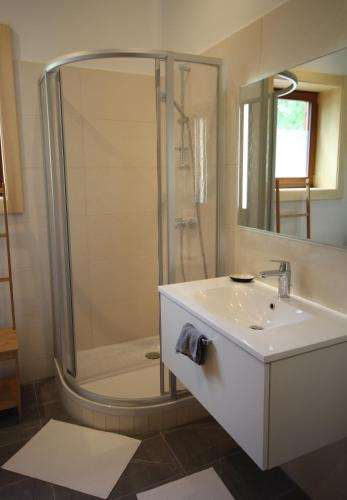 a white bathroom with a shower and a sink at Chalet Stressless in Presseggen