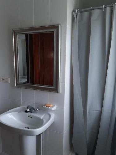 a bathroom with a sink and a mirror at Area Pequena in Malpica