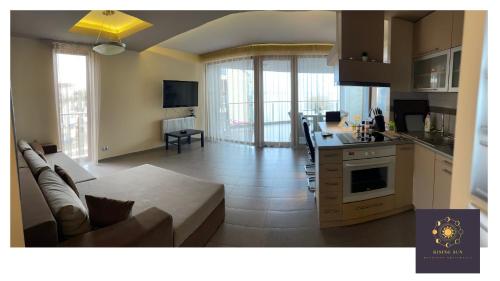 cocina y sala de estar con sofá y mesa en Rising Sun Panorama Apartman I, en Siófok