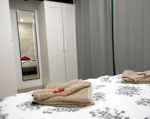 a bedroom with towels on a bed with a mirror at Niedaleko od Centrum ale Z dala od tłumów in Lublin