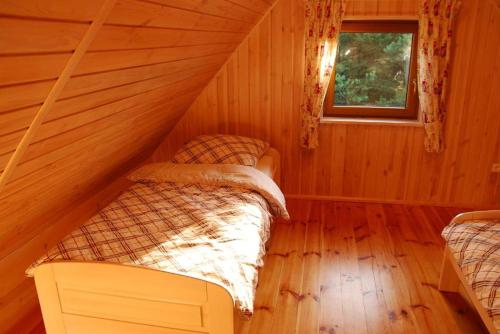 Studzienice的住宿－Chatka nad jeziorem，小木屋内一间卧室,配有两张床
